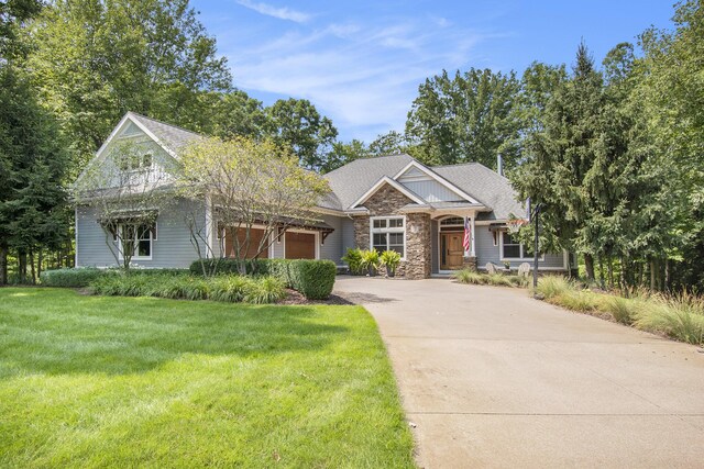 craftsman inspired home with a garage, stone siding, driveway, and a front lawn