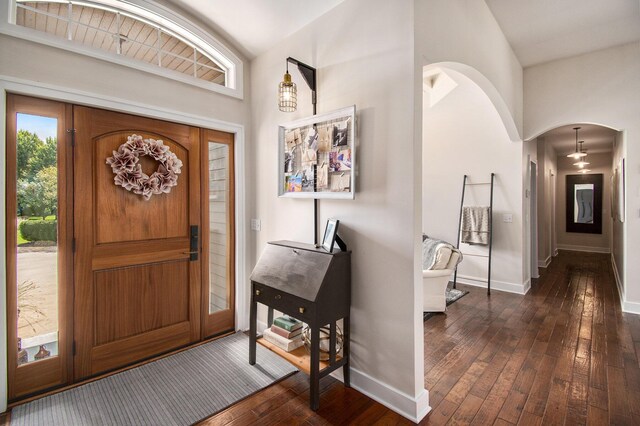 entryway with dark hardwood / wood-style flooring and high vaulted ceiling