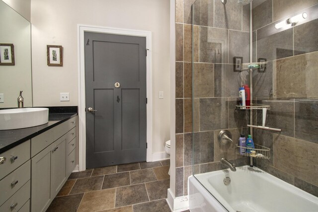 full bathroom with tiled shower / bath combo, tile patterned flooring, toilet, and vanity