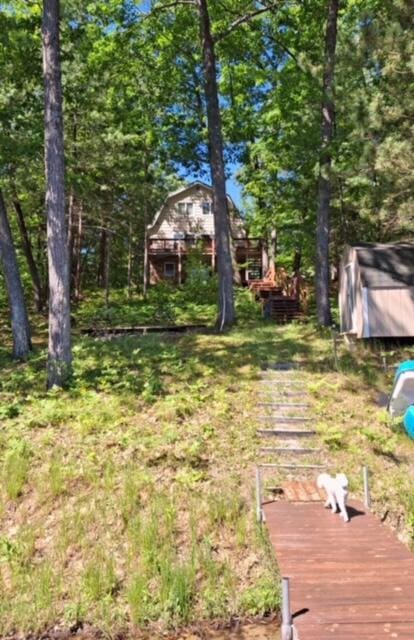 view of yard with a storage shed, an outbuilding, and a deck