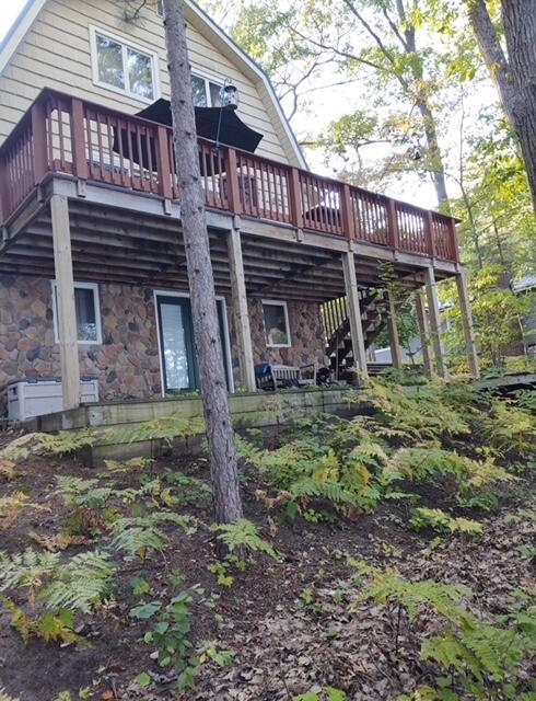 rear view of property featuring a wooden deck