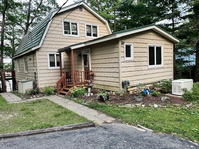 dutch colonial with a gambrel roof and a front lawn