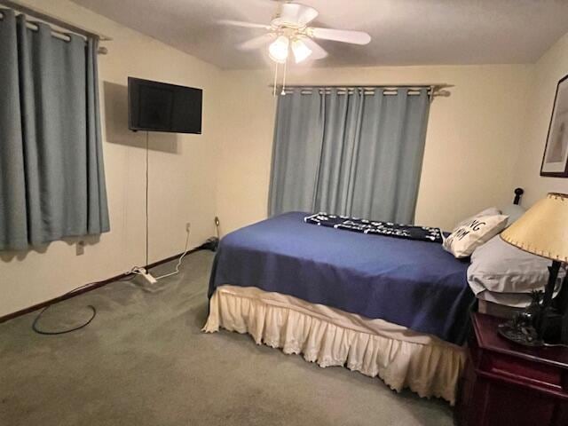 carpeted bedroom featuring ceiling fan and vaulted ceiling