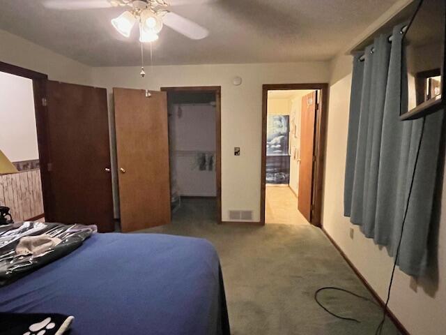 bedroom featuring ceiling fan, a closet, and light carpet