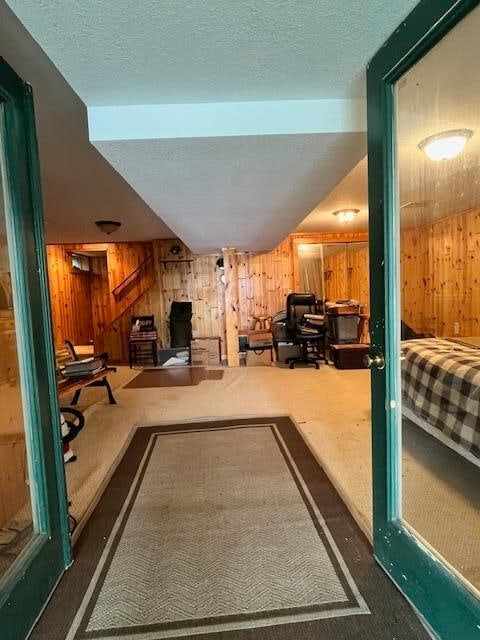 interior space with wood walls, a textured ceiling, and lofted ceiling