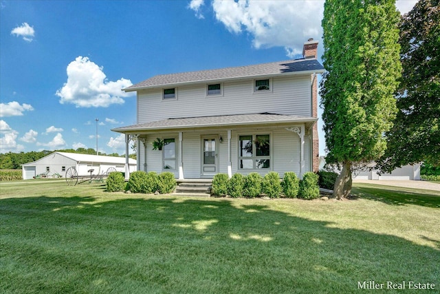 view of front of property featuring covered porch, a chimney, and a front yard