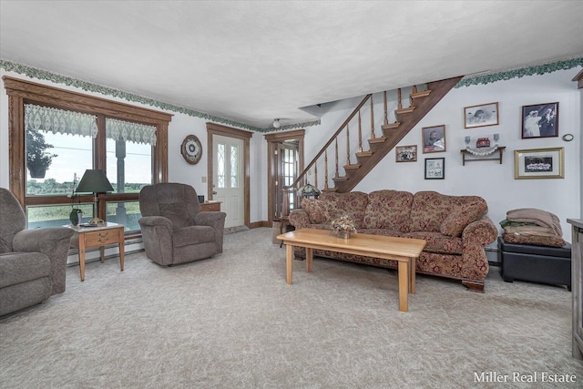 carpeted living room with stairs and a baseboard radiator