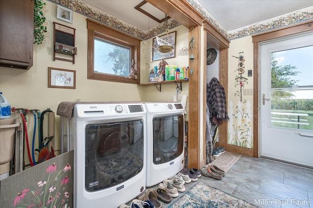 laundry area featuring washer and clothes dryer, cabinet space, and a wealth of natural light