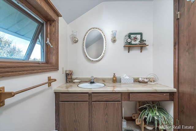 bathroom featuring lofted ceiling and vanity