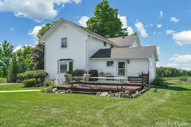 back of house featuring a yard, roof with shingles, and a wooden deck