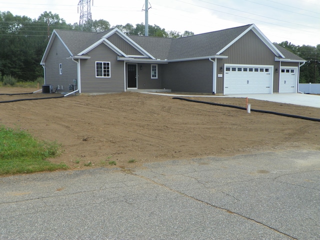 view of front of property with a garage and central air condition unit