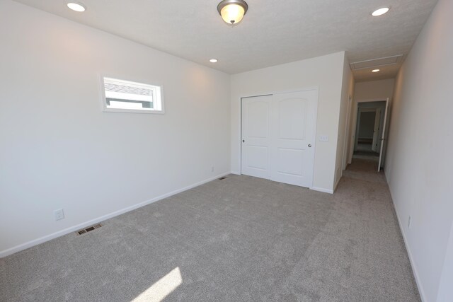 unfurnished bedroom with a closet and light carpet