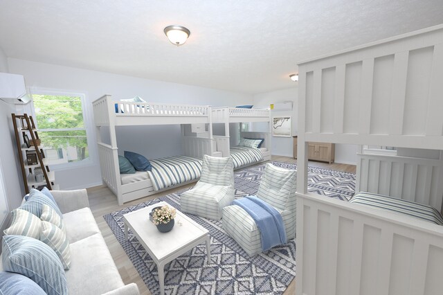 bedroom with light wood-type flooring and a wall unit AC