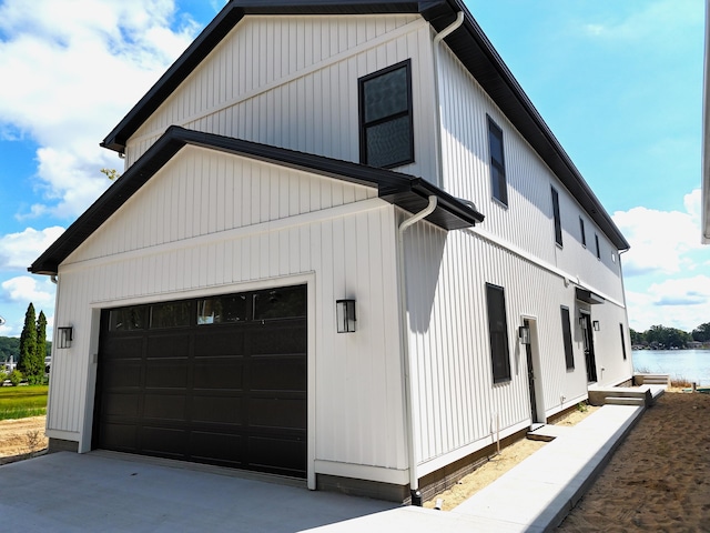 view of side of property with a water view and a garage