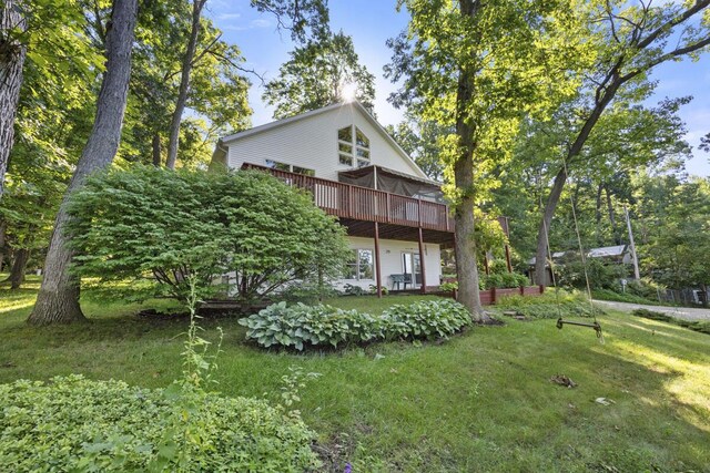 exterior space featuring a wooden deck and a lawn