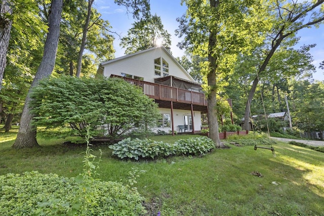 rear view of house with a yard and a wooden deck