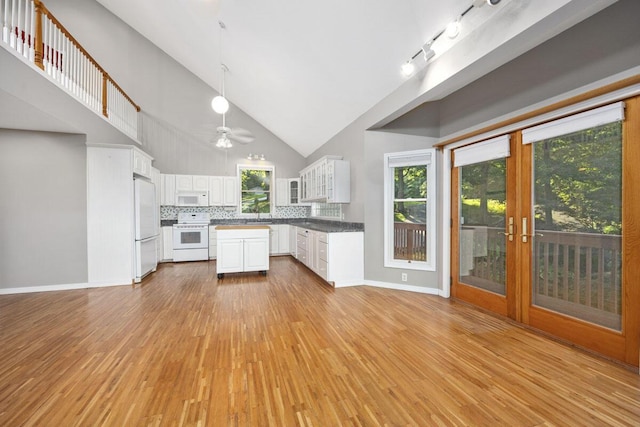 kitchen with decorative light fixtures, white appliances, white cabinetry, and light wood-type flooring