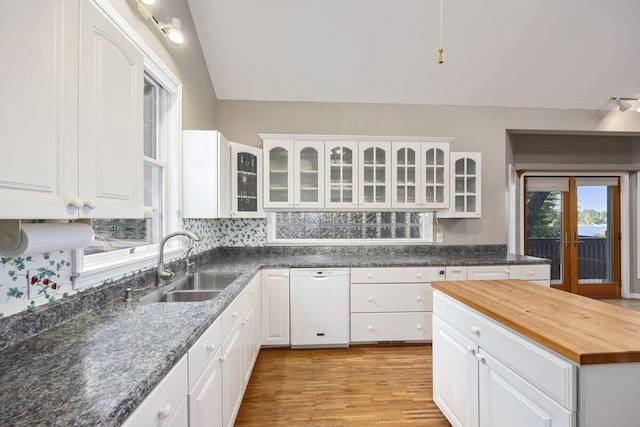 kitchen with butcher block countertops, light hardwood / wood-style floors, sink, white dishwasher, and white cabinets