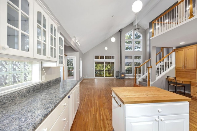 kitchen with light hardwood / wood-style flooring, wooden counters, white cabinetry, and a center island