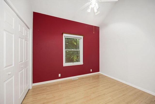 unfurnished room with lofted ceiling, ceiling fan, and light hardwood / wood-style flooring