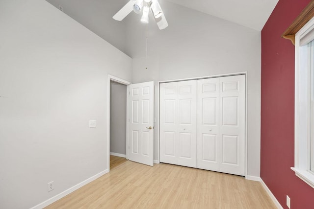 unfurnished bedroom with ceiling fan, a closet, high vaulted ceiling, and light hardwood / wood-style floors