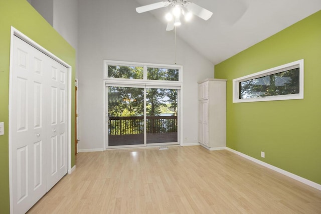 unfurnished room with ceiling fan, light hardwood / wood-style flooring, and high vaulted ceiling