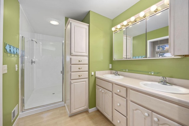 bathroom featuring hardwood / wood-style floors, vanity, and a shower with door