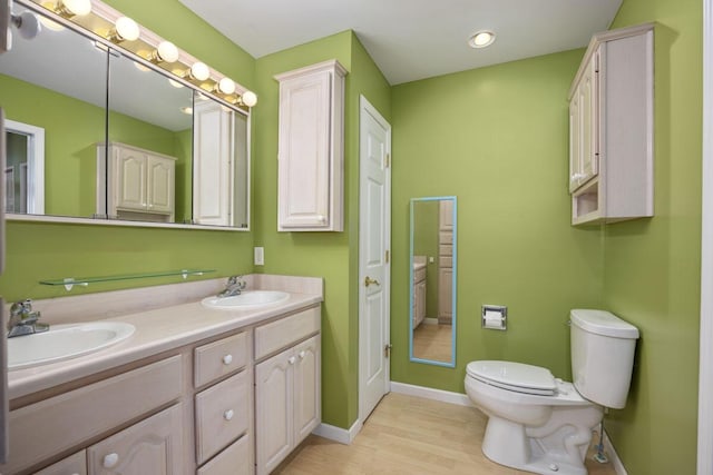 bathroom with hardwood / wood-style flooring, vanity, and toilet