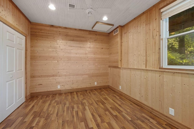 unfurnished room featuring wood walls and wood-type flooring