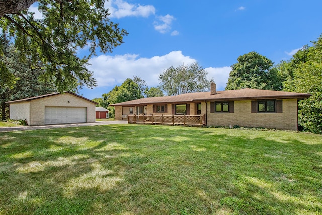 ranch-style house featuring a garage, an outbuilding, and a front yard