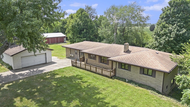 view of front of property featuring an outbuilding, a detached garage, a front yard, brick siding, and a chimney