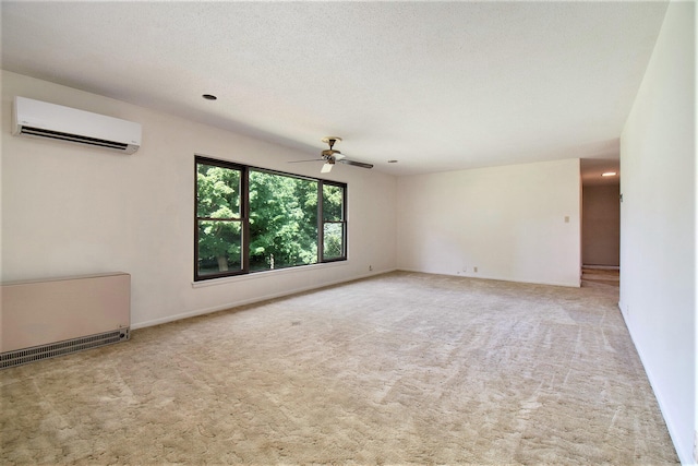 carpeted spare room featuring ceiling fan, a textured ceiling, and a wall mounted air conditioner