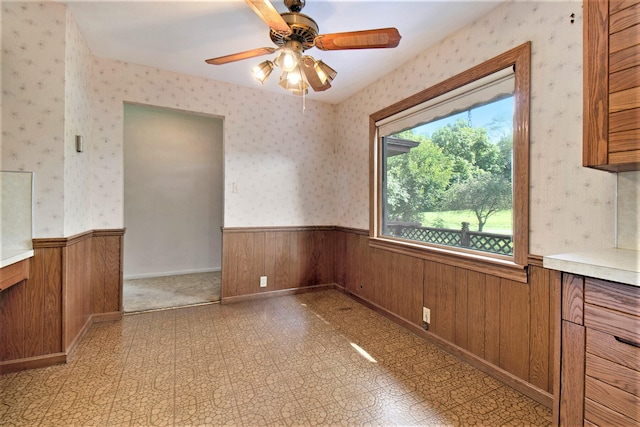 tiled spare room featuring ceiling fan and a healthy amount of sunlight