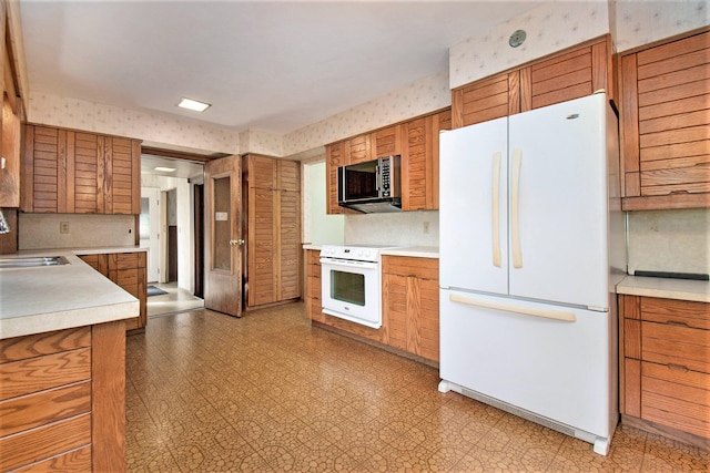 kitchen with light tile patterned flooring, sink, white refrigerator, decorative backsplash, and stove