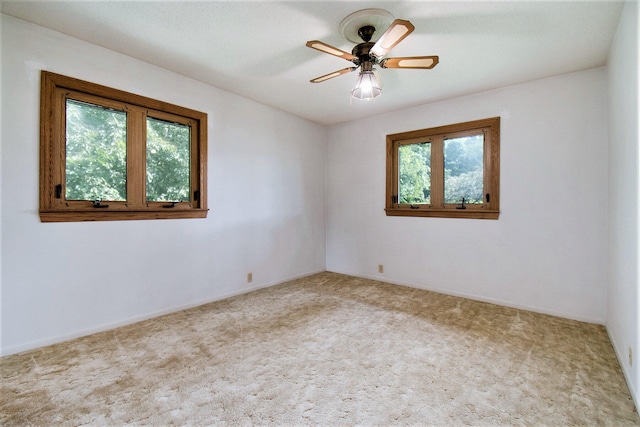 spare room with ceiling fan and light carpet