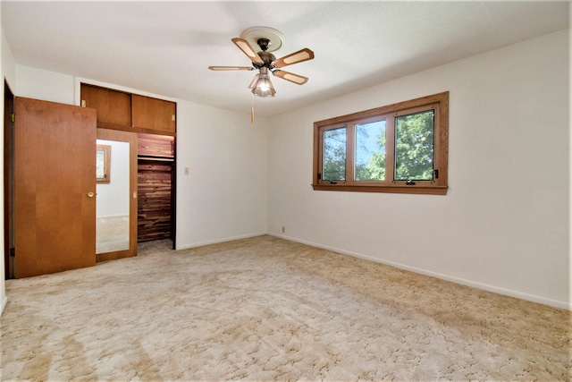 unfurnished bedroom with light colored carpet, a closet, and ceiling fan