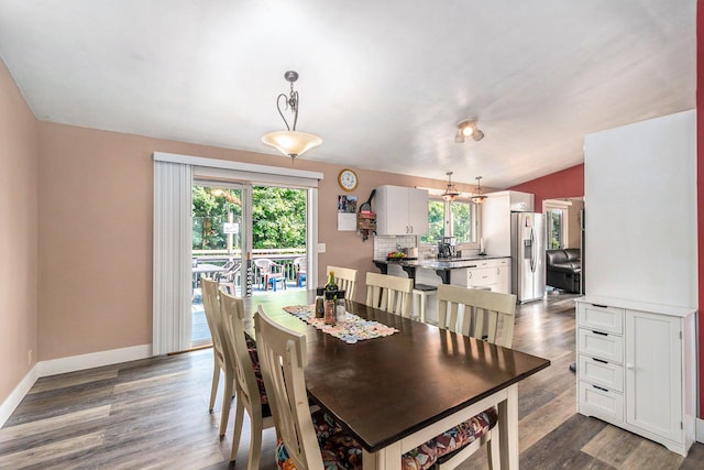 dining room with vaulted ceiling and wood-type flooring