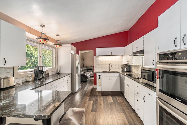 kitchen featuring dark hardwood / wood-style flooring, stainless steel appliances, sink, decorative backsplash, and lofted ceiling