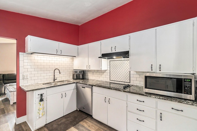 kitchen featuring dark stone countertops, stainless steel appliances, sink, and dark hardwood / wood-style floors