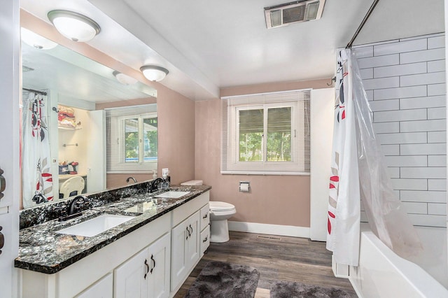 full bathroom with wood-type flooring, toilet, plenty of natural light, and vanity