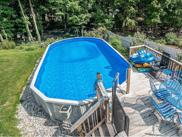 view of pool featuring a wooden deck and a yard