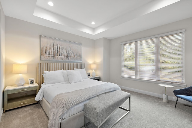 bedroom with recessed lighting, a tray ceiling, baseboards, and carpet floors