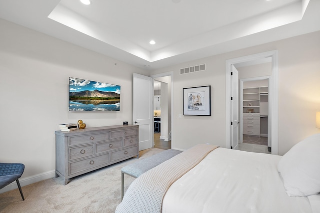 bedroom with visible vents, light carpet, recessed lighting, baseboards, and a raised ceiling