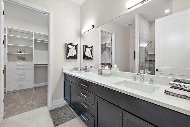 full bath featuring double vanity, a sink, a shower stall, a walk in closet, and toilet