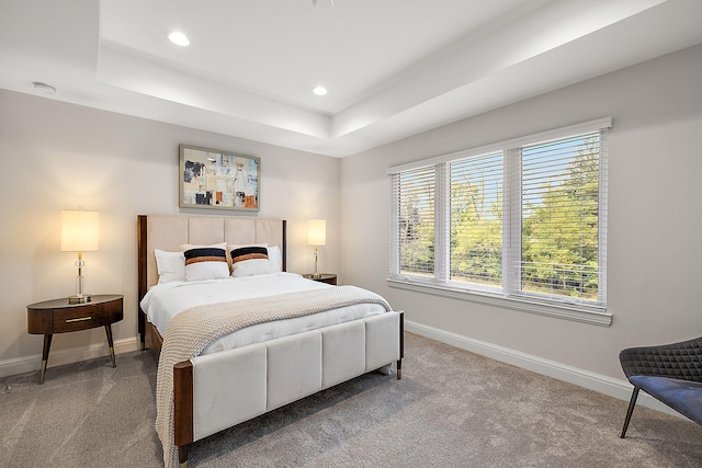 carpeted bedroom featuring recessed lighting, baseboards, and a raised ceiling