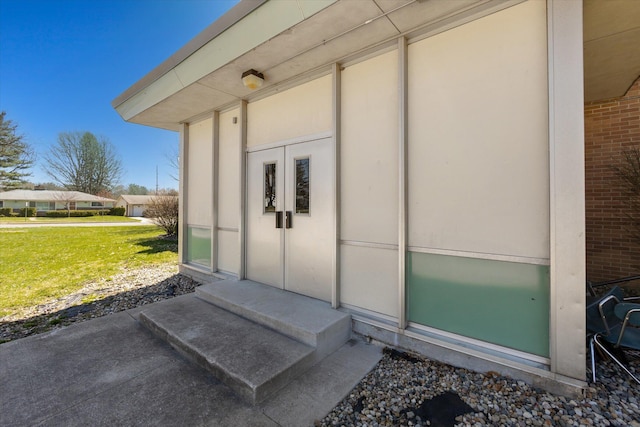 view of exterior entry featuring a yard