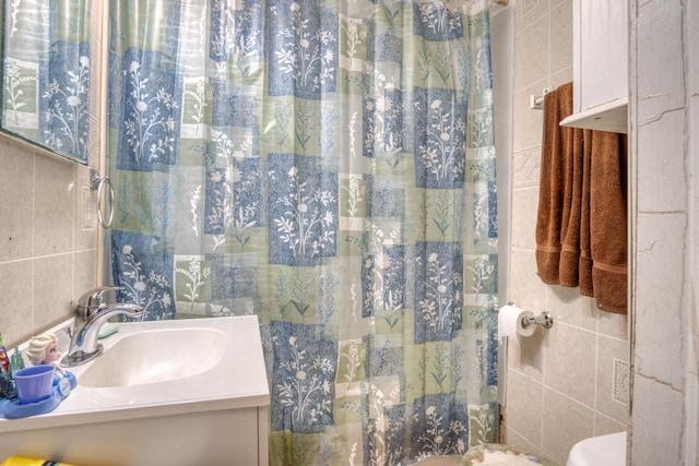 bathroom with tile walls, curtained shower, and vanity