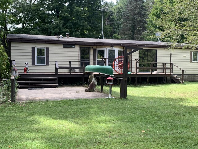 back of property with a yard and a wooden deck