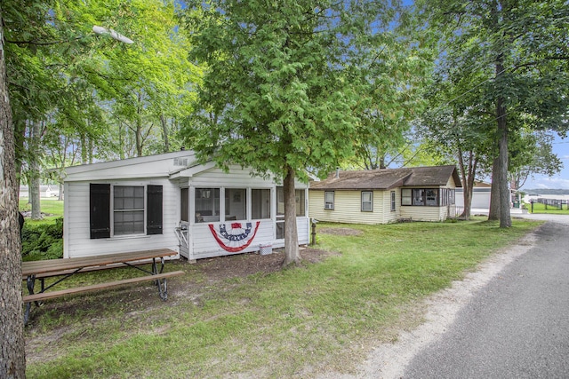 view of front facade with a front yard, driveway, and an outdoor structure