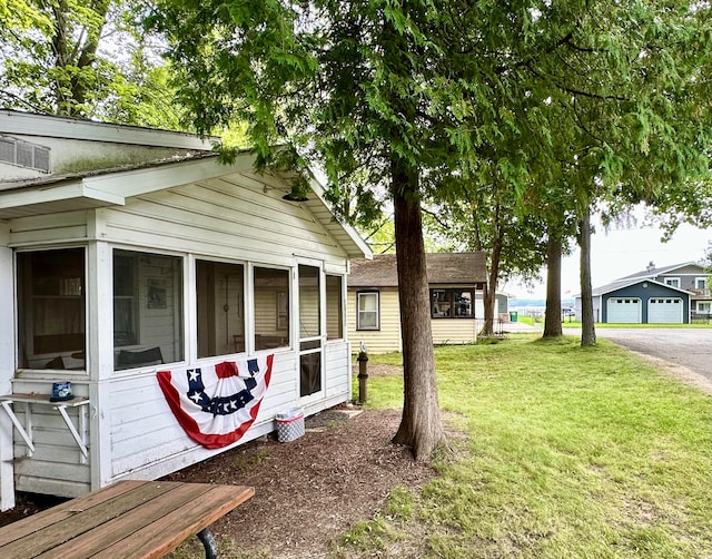 view of side of home featuring a sunroom and a lawn